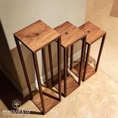 three wooden tables sitting on top of a tiled floor