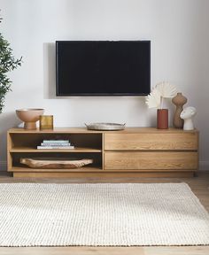 a flat screen tv mounted to the side of a wooden entertainment center