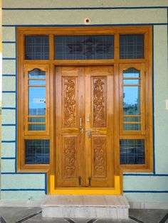 a wooden door with two windows in front of a building