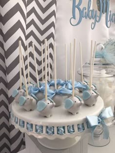 there is a cake with blue decorations on it and candles in the shape of elephants