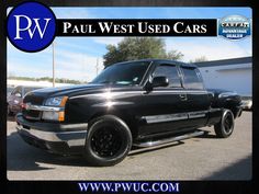 a black truck parked in a parking lot next to other cars with the words paul west used cars on it