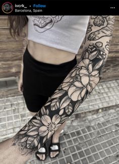 a woman's arm with black and white flowers on the left side of her body