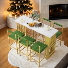 a white table with green chairs in front of a christmas tree