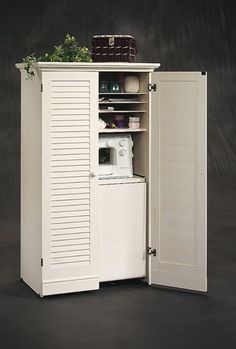 a white cabinet with an open door on the front and bottom, filled with items