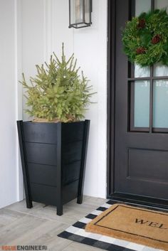 a planter with a christmas wreath on the front door