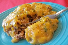 a blue plate topped with meat covered in cheese