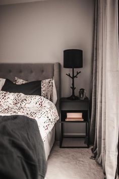 a bed sitting next to a night stand in a bedroom