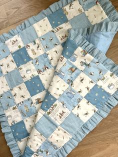 a blue and white baby quilt on the floor