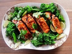 a white plate topped with chicken and broccoli on top of a wooden table