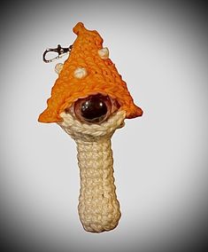 a crocheted keychain with an orange hat on it's head