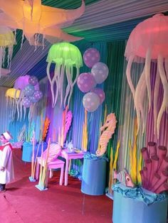 a room filled with lots of jellyfish and other colorful decorations on the walls,