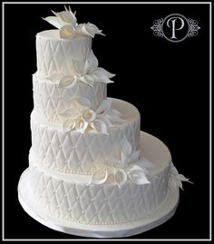 a three tiered white wedding cake with flowers