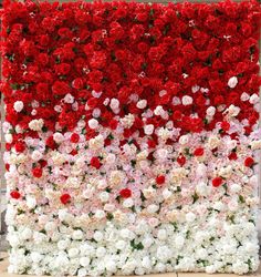 a large flower wall with red, white and pink flowers in the center is shown