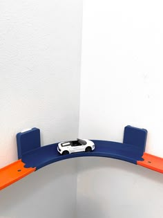 a toy car is on top of a curved shelf