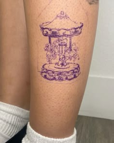 a woman's leg with a tattoo on it that has an image of a carousel