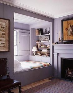 a room with a bed, fireplace and bookshelf in the middle of it