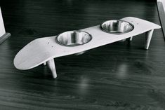 an advertisement with two bowls on top of a surfboard shaped dog bowl stand that reads, patineta sin usar?