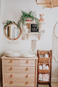 a baby's room with a crib, dresser and hanging baskets on the wall