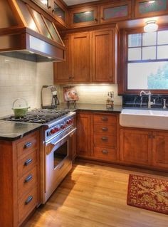 a kitchen with wooden cabinets and stainless steel stove top oven, sink, dishwasher and microwave