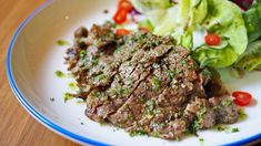 a close up of a plate of food with lettuce and meat on it