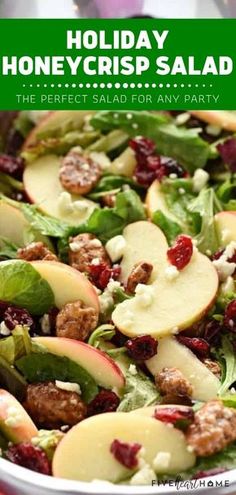 a salad with apples, spinach and cranberries in it