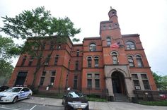 two police cars parked in front of an old brick building with a flag on top