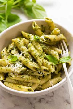 a white bowl filled with pasta and pesto