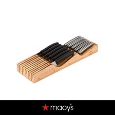 a wooden cutting board with four knives on it and the words macy's above it