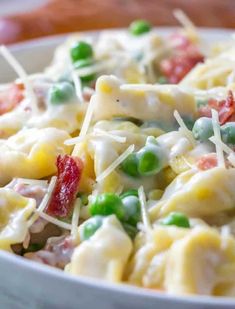 a white bowl filled with pasta and peas