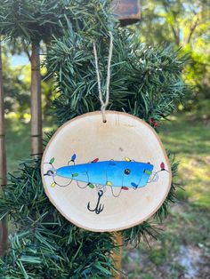 a blue fish ornament hanging from a tree