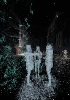 three people standing in the middle of a field at night with trees and buildings behind them