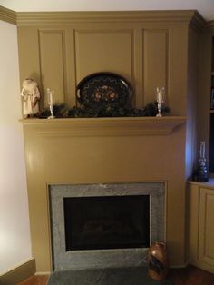 a living room with a fireplace, mantle and candles on top of the mantel