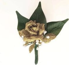 a gold rose with green leaves and white blooms on a white background, ready to be used as a boutonniere