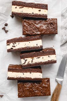 chocolate brownies with ice cream on top are lined up next to a spatula