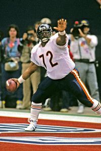 a football player throwing a ball in front of a crowd with people standing behind him