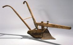 an old wooden tool with two large metal tools attached to it's back end