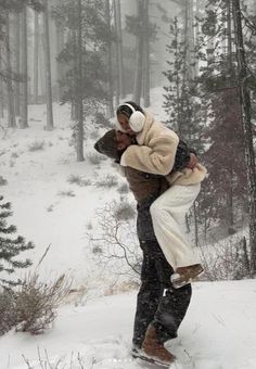 a man carrying a woman on his back in the snow