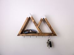 a pair of triangle shaped wooden shelves with keys hanging from the hooks on each side