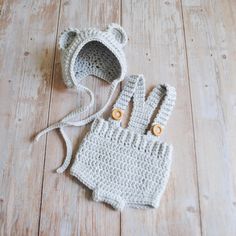 a crocheted bear hat and mittens are laying on the floor next to each other