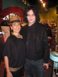 a man and woman standing next to each other in front of a store display case