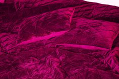 the comforter is made up with purple sheets and pillows on top of each other