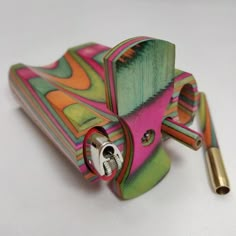 a multicolored lighter with a key on the side and a pen in it