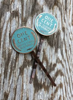 two pins with the words one cent on them