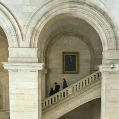 people are walking up and down the stairs in an old building with paintings on the walls