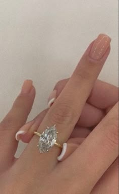 two hands holding an engagement ring on top of each other with a diamond in the middle