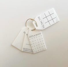 three tags are attached to each other on a white surface with black dots and lines