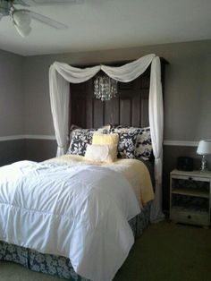 a bedroom with a canopy bed and chandelier hanging from it's ceiling