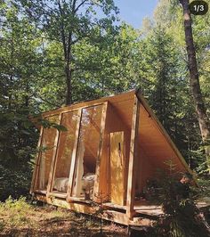 a small wooden cabin in the woods surrounded by trees