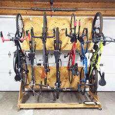 a bike rack with many bikes mounted to it's sides and attached to the wall