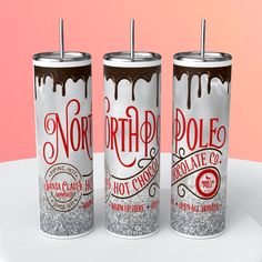 three cans of north pole hot chocolate on a white plate with pink background and red lettering